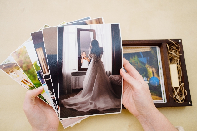 A person looking through a series of photographs. The top one is of a bride looking in the mirror