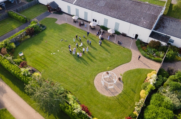 Birdseye view of a white building with manicured grass