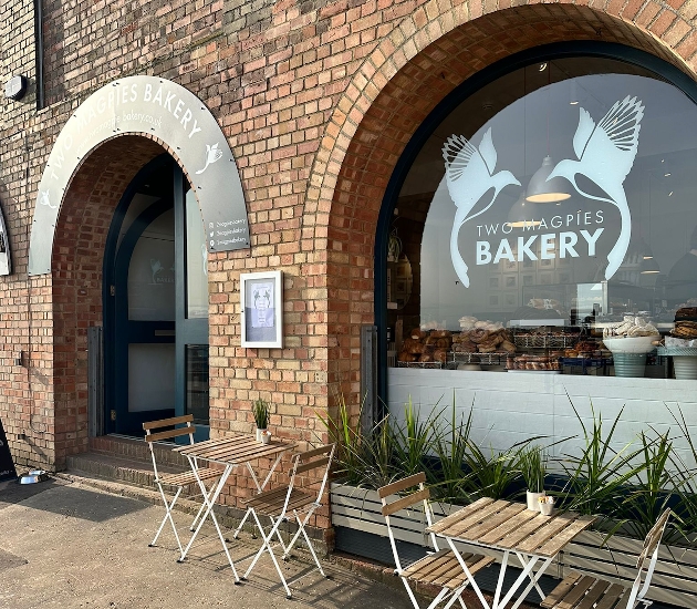 The exterior of a brick building with a Two Magpies Bakery sign