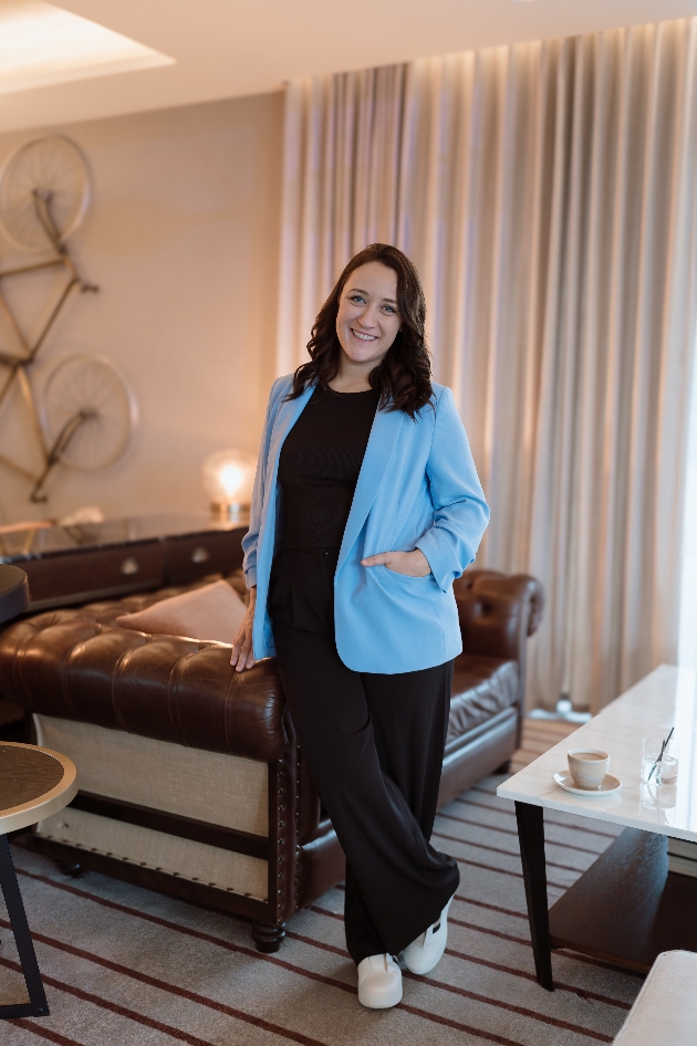 A woman standing in a living room while smiling at the camera