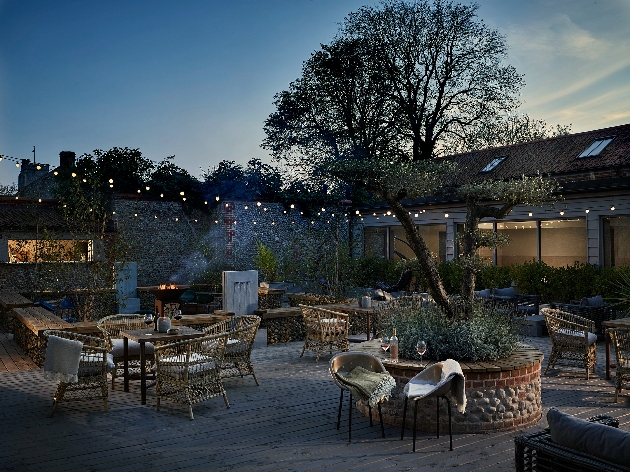 An outdoor courtyard with chairs and foliage