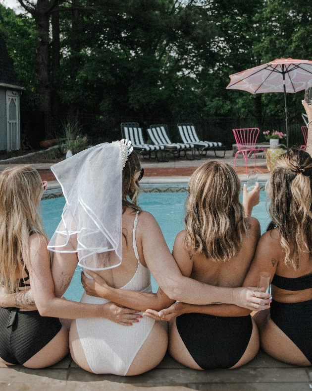 group of women sitting by a pool