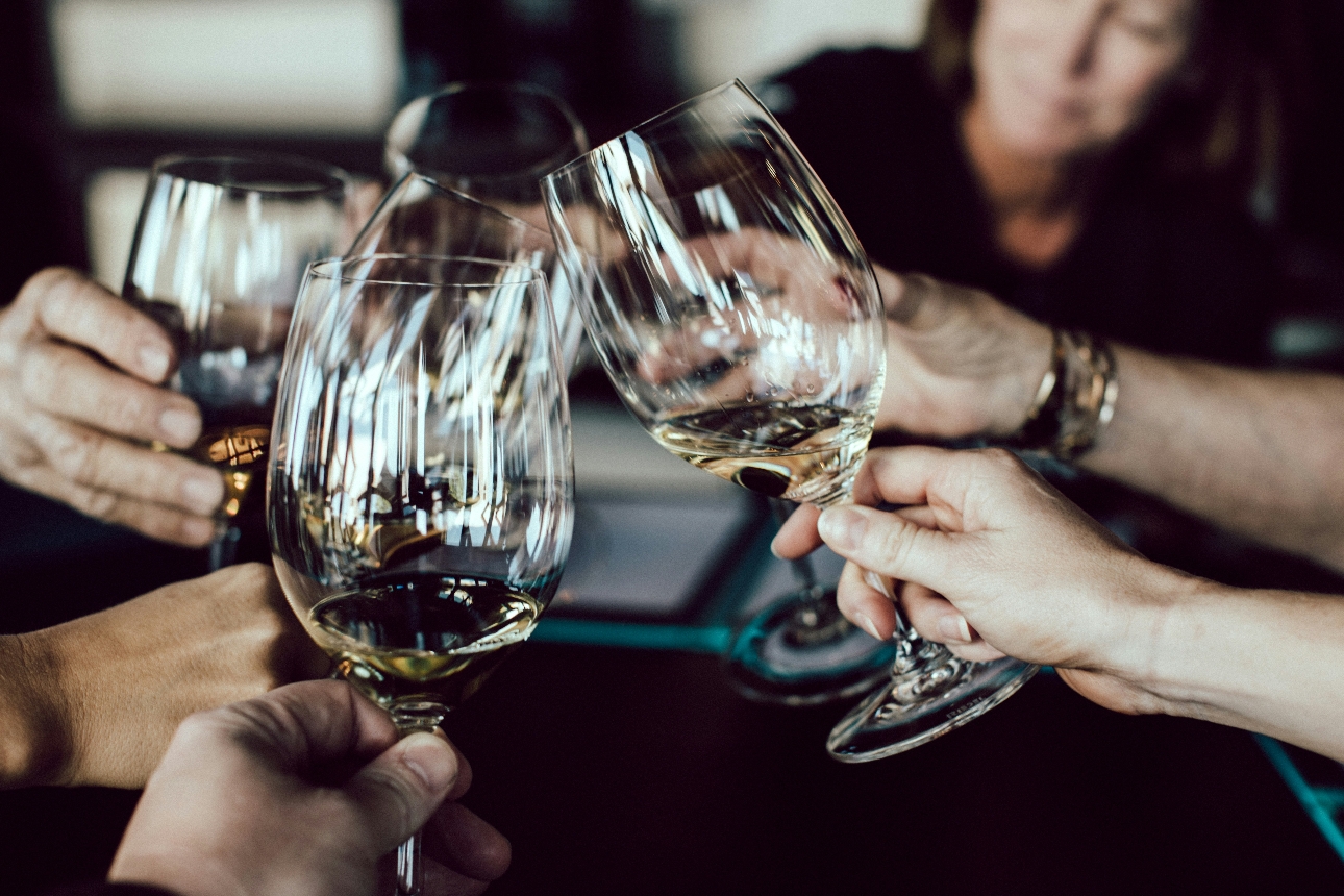 group of people cheers with wine glasses