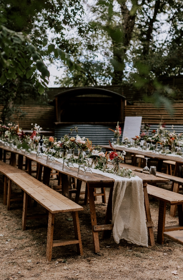 A long wooden table decorated with flowers