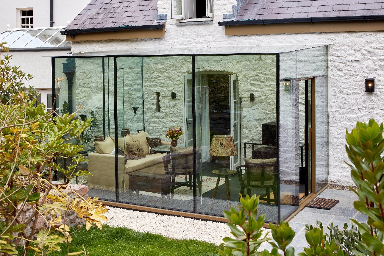 tables and chairs in glass room half outside