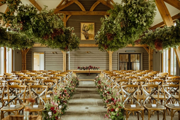 A barn decorated with wooden chairs and flowers