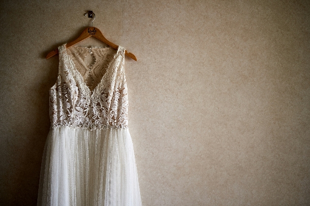 A wedding dress hanging up against a wall