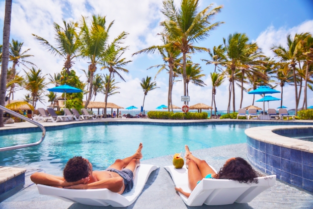 A man and woman sunbathing by the pool